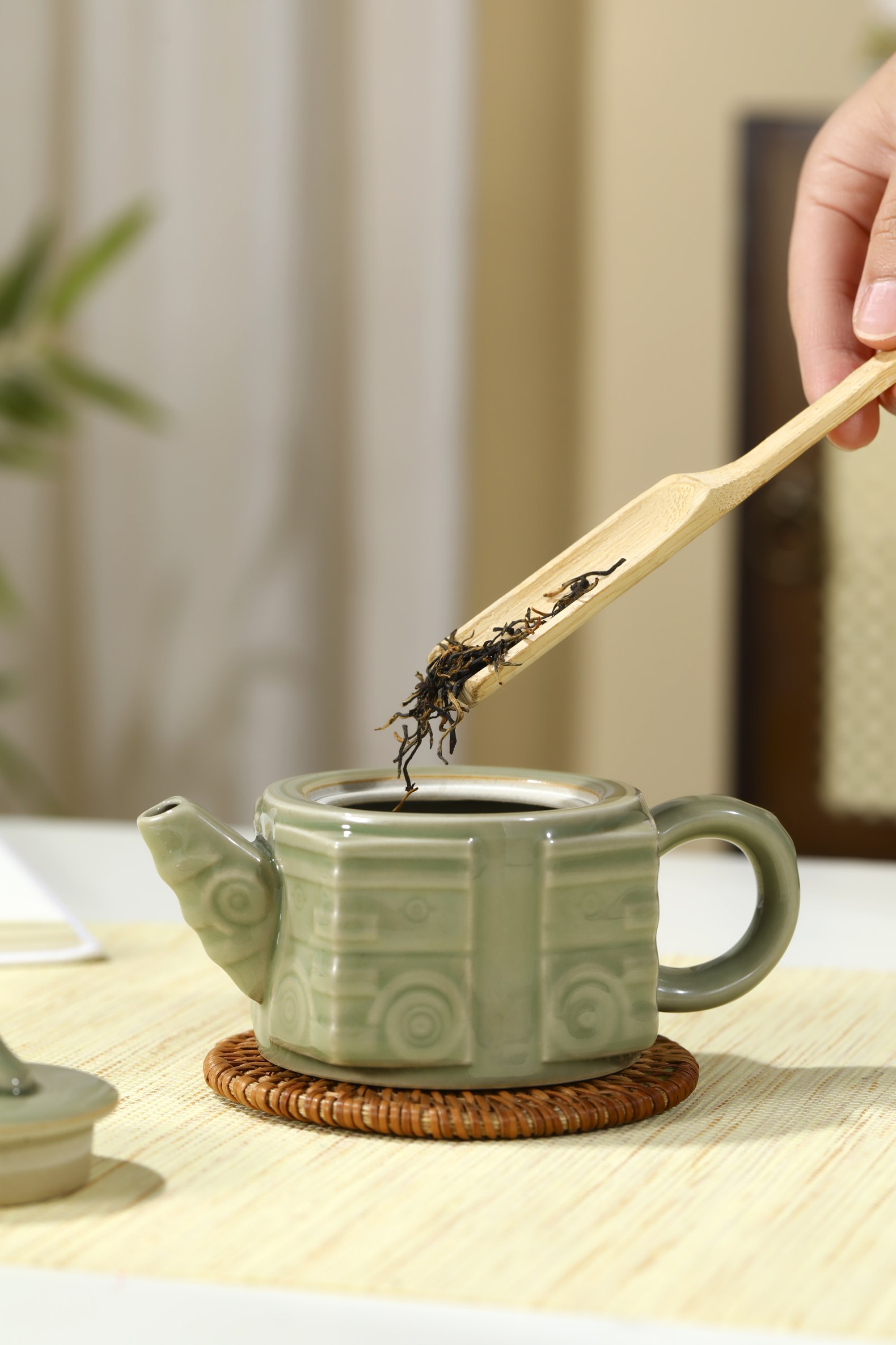 向茶壶投茶的日常使用场景