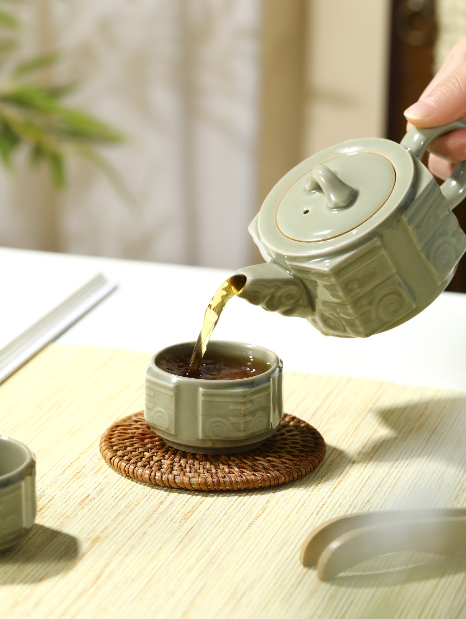 提壶向茶杯中注茶的场景